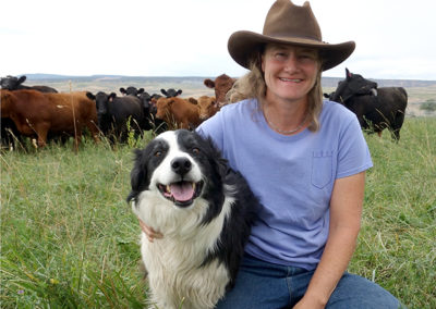 Cynthia with her trusty border collie Rex with cows in the background