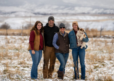 Izzi, Ira, Cynthia, and CeCe holding Fletcher with snowy landscape